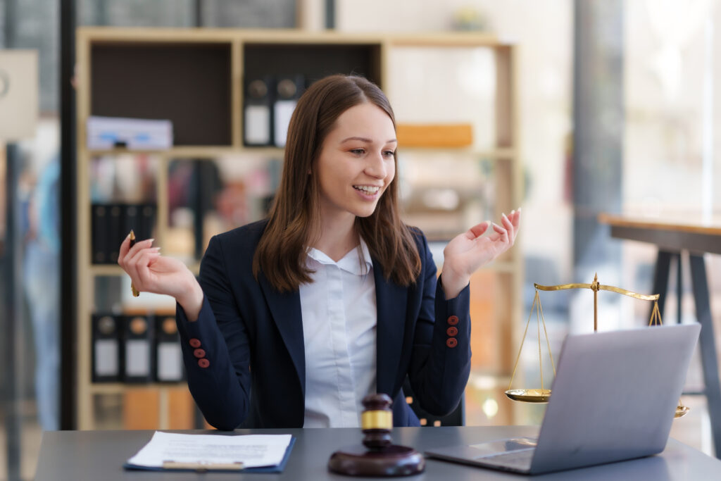 Asian female lawyer chatting online with client on laptop discussing details of lawsuit.