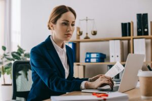 focused female lawyer working on laptop at workplace in office