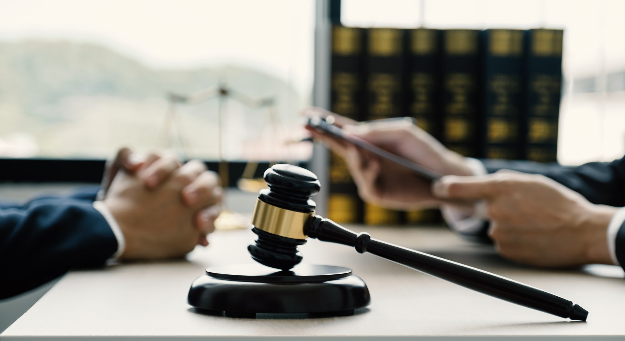 Lawyer hand holding pen and providing legal consult business dispute service to the man at office