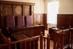 Part of spacious courtroom with wooden furniture and leather chairs