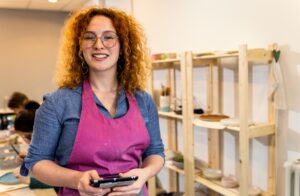 Portrait of female business owner in front of her pottery studio.