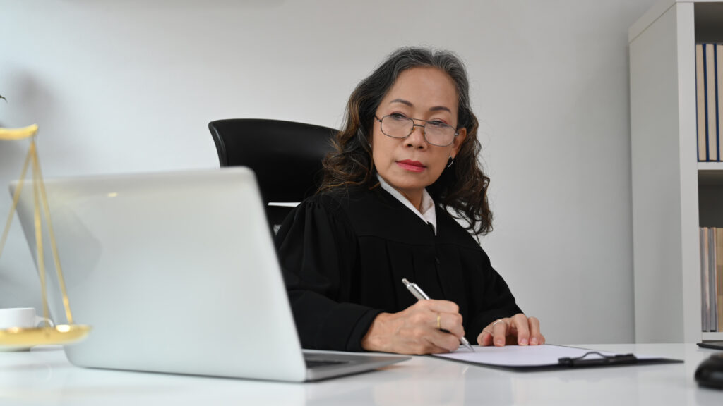 Smart mature judge talking to her clients for providing law consultation, legal advice online.