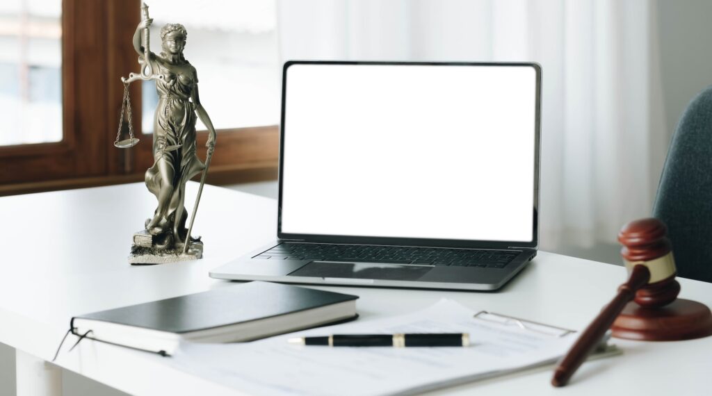 Workspace of lawyer with laptop blank white screen and law wooden gavel,legal book and brass scale